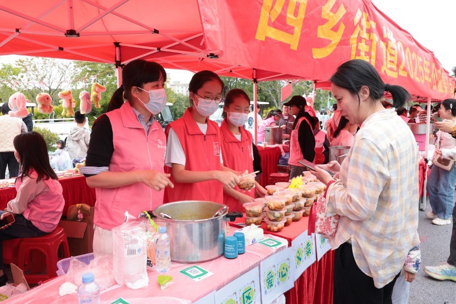 Volunteers serving food and interacting with visitors at the charity bazaar