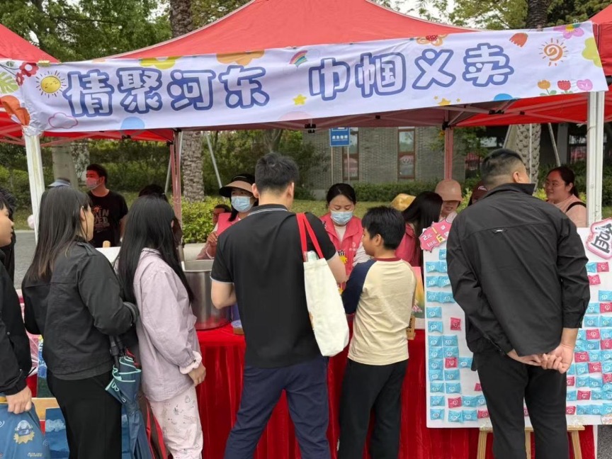 A busy charity sale booth welcoming families and community members
